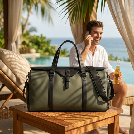 Man sitting by a pool holding a beer bottle with a green caveri waterproof duffel bag on a table in the foreground.