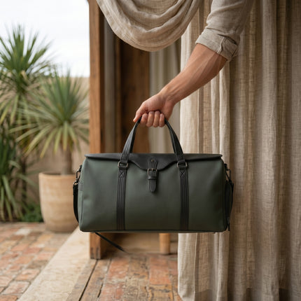 Person holding caveri's marlowe green duffel bag outdoors with plants and curtains in the background