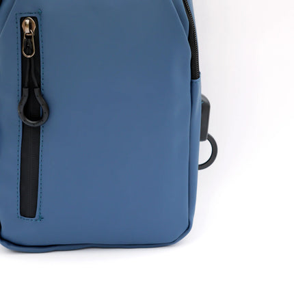 Caveri day bag in slate blue showing front zip pocket and gold zipper pull detail