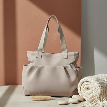 Caveri day bag in warm stone with structured handles and side pockets, front view