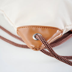 Caveri drawstring bag tan leather corner detail with silver eyelet and braided brown cord
