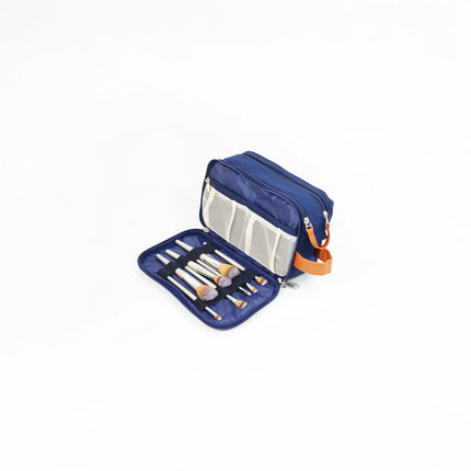 Caveri navy toiletry bag open showing makeup brush organiser panel with tan leather handle