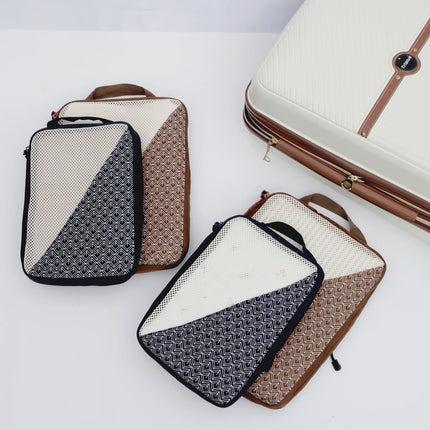 Caveri Nomad Kit packing cubes in navy and tan geometric print with mesh panels, styled with cream hardside luggage