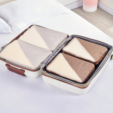 Caveri packing cubes organised inside open cream suitcase on bed, showing neutral and tan mesh cubes