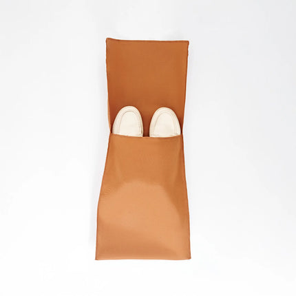 Caveri tan shoe bag open flat with white loafers tucked inside, shown from above