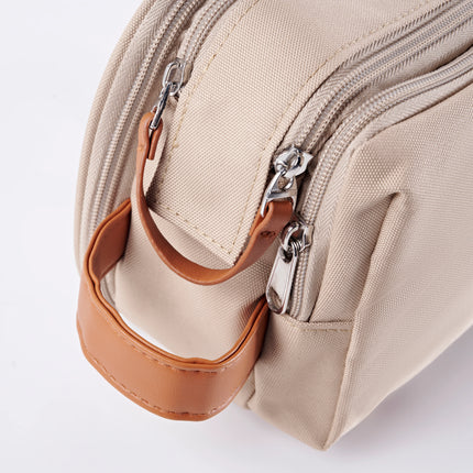 Caveri toiletry bag in sand with tan leather handle and silver zip detail, close-up