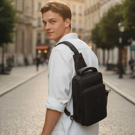 Man wearing Caveri Tony black crossbody sling bag over one shoulder on a cobblestone city street