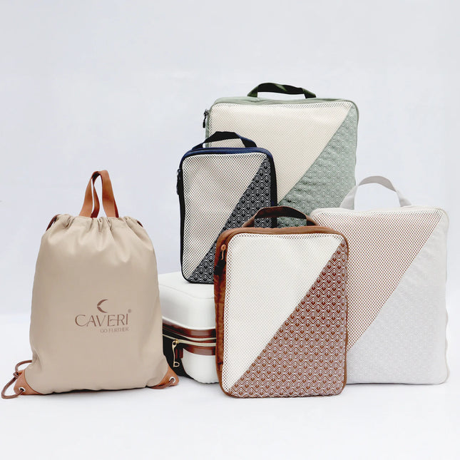 Caveri Wanderlust Kit with packing cubes in sage, navy and tan plus drawstring bag arranged together