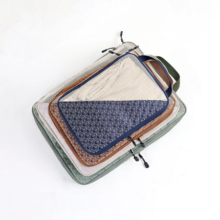 Caveri Wanderlust Kit packing cubes stacked in sage, navy, tan and blush with geometric print panels