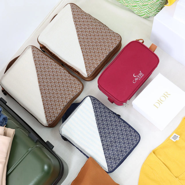 Caveri Wanderlust packing cubes in tan print and navy with red toiletry bag laid out beside an open suitcase
