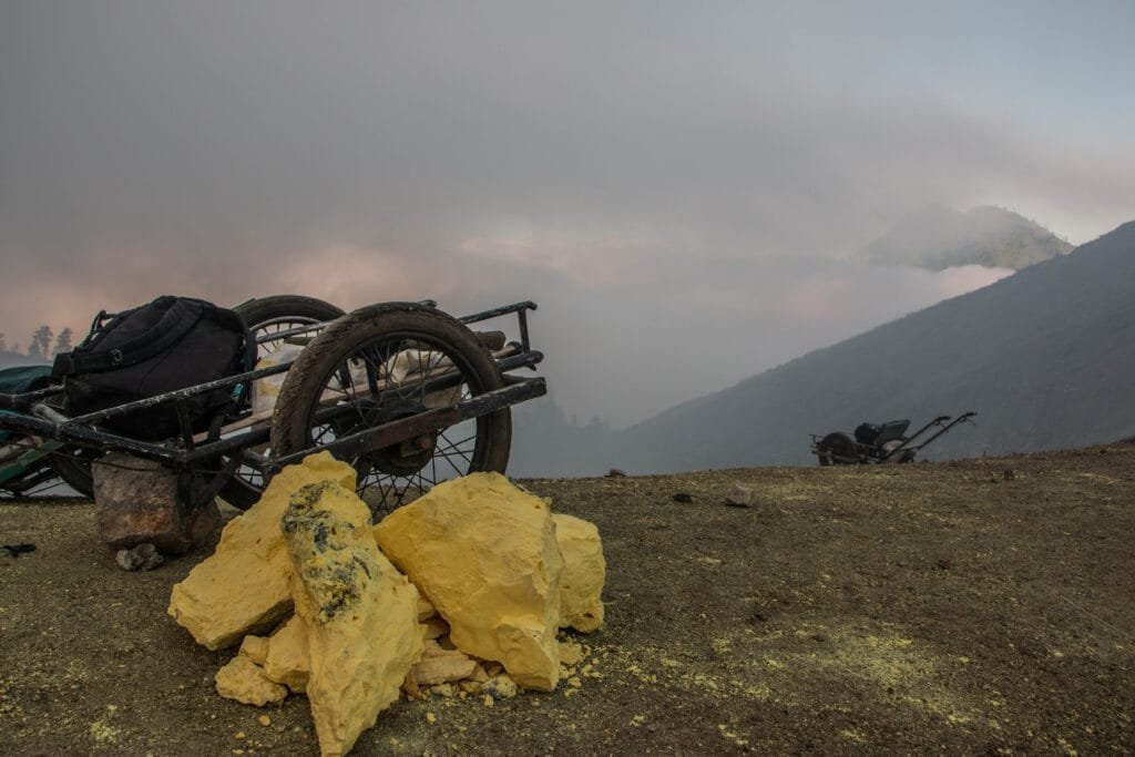 a wheelbarrow filled with sulphur blocks down the rocky path of Kawah Ijen in Java, Indonesia.